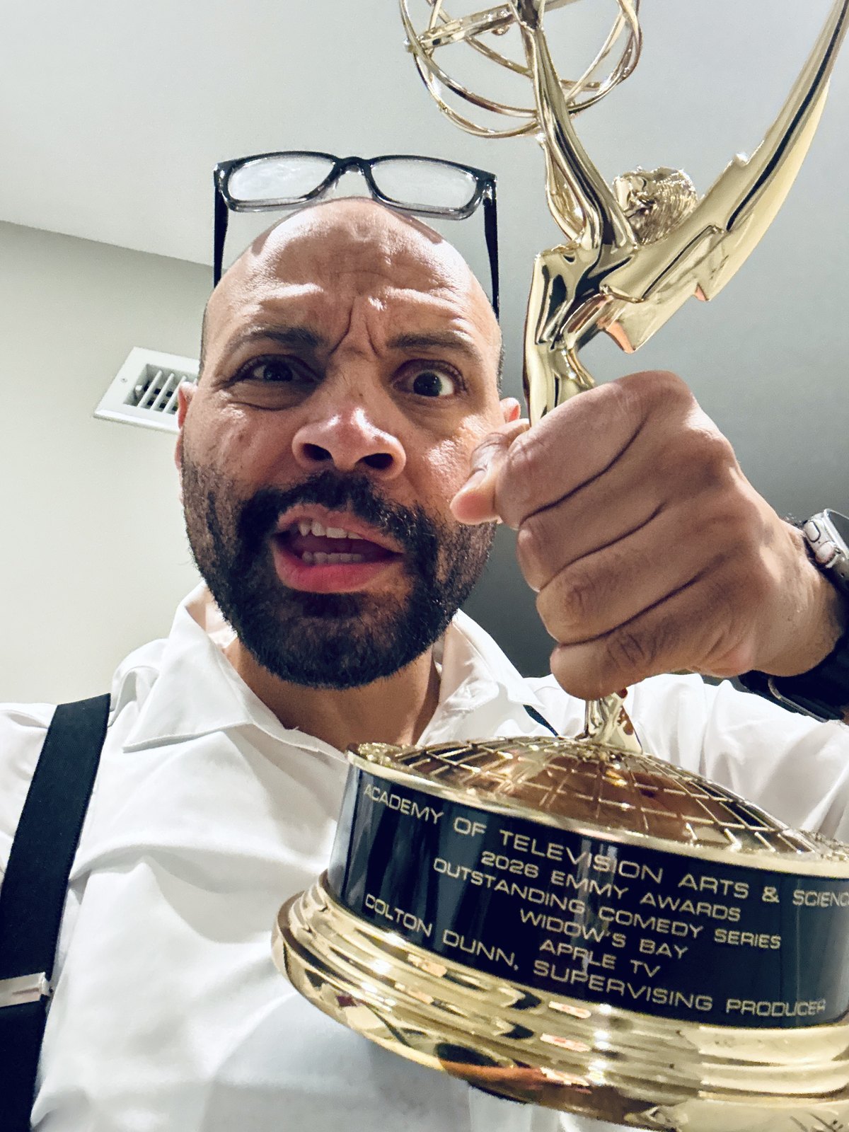 Colton Dunn holding his 2026 Emmy statuette, the plate engraved Outstanding Comedy Series, Widow's Bay
